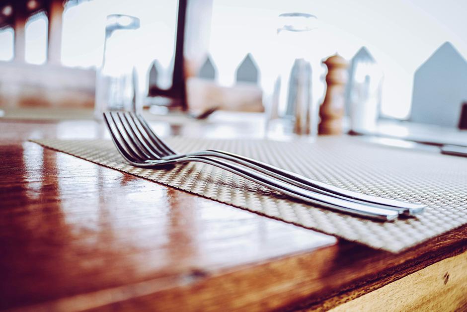 Two Stainless Steel Forks on Top of Place Mat